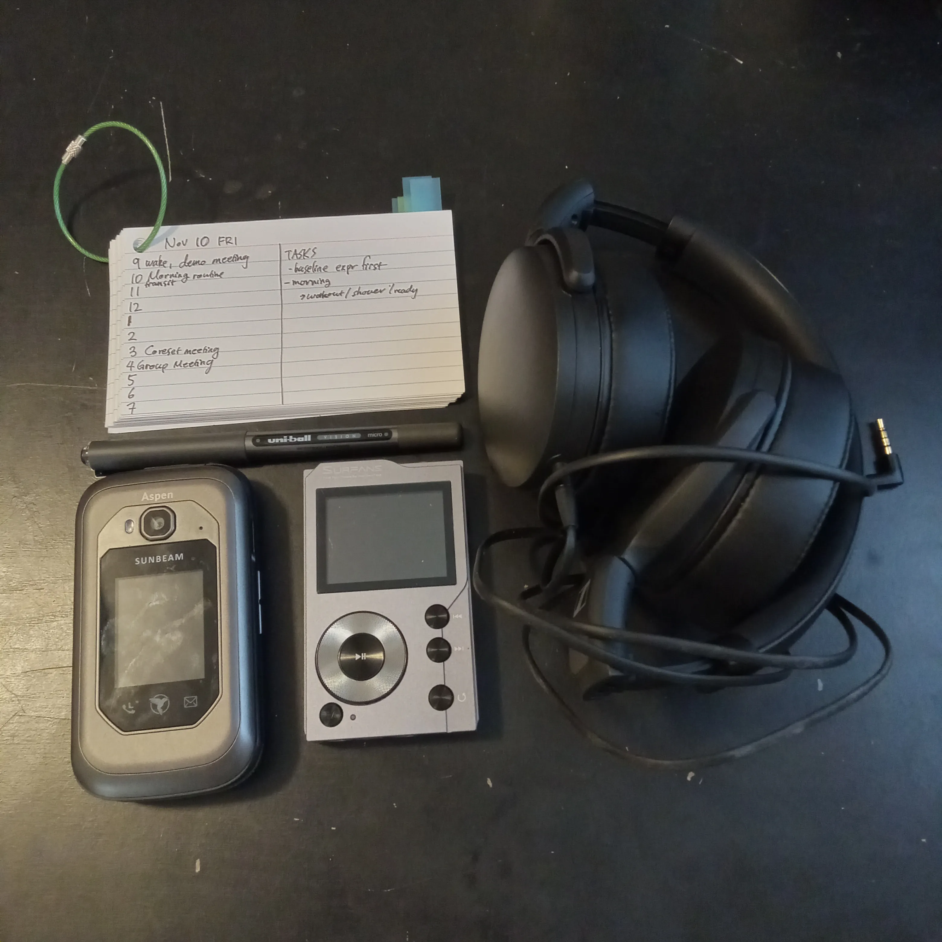 Photograph of a hipster PDA, dumb phone, mp3 player, and headphone.